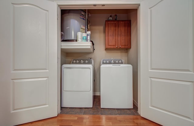 1711 Old Spanish Trl Unit 401, Houston, TX 77054 - washroom featuring cabinet space, washer and clothes dryer, water heater, and wood finished floors