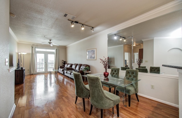 1711 Old Spanish Trl Unit 401, Houston, TX 77054 - dining space featuring rail lighting, ornamental molding, ceiling fan, wood finished floors, and baseboards