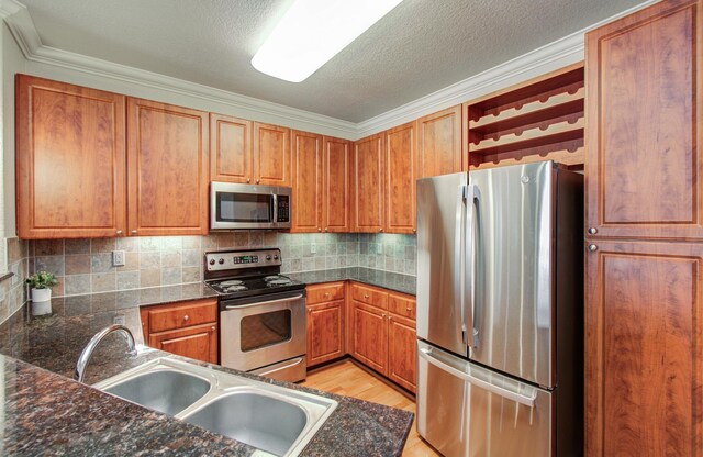 1711 Old Spanish Trl Unit 401, Houston, TX 77054 - kitchen with stainless steel appliances, a sink, open shelves, decorative backsplash, and ornamental molding