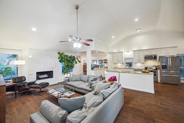 2227 Holly Knoll St, Houston, TX 77077 - living area featuring dark wood-style floors, ceiling fan, a premium fireplace, recessed lighting, and high vaulted ceiling