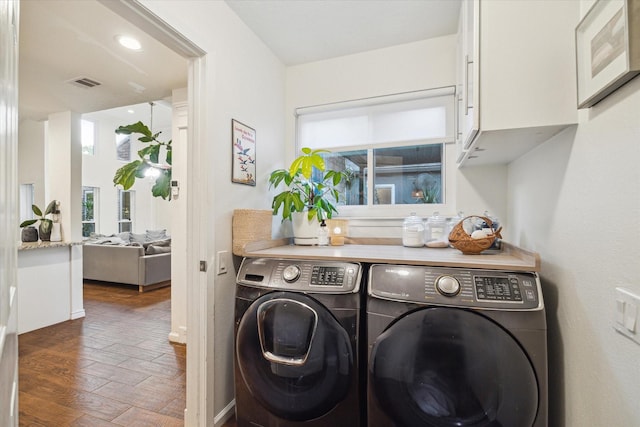 2227 Holly Knoll St, Houston, TX 77077 - laundry area with washing machine and clothes dryer, cabinet space, and wood finished floors