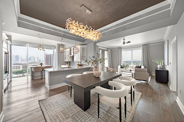 3333 Allen Pkwy Unit 1302, Houston, TX 77019 - dining area featuring a chandelier, a raised ceiling, wood-type flooring, baseboards, and ornamental molding