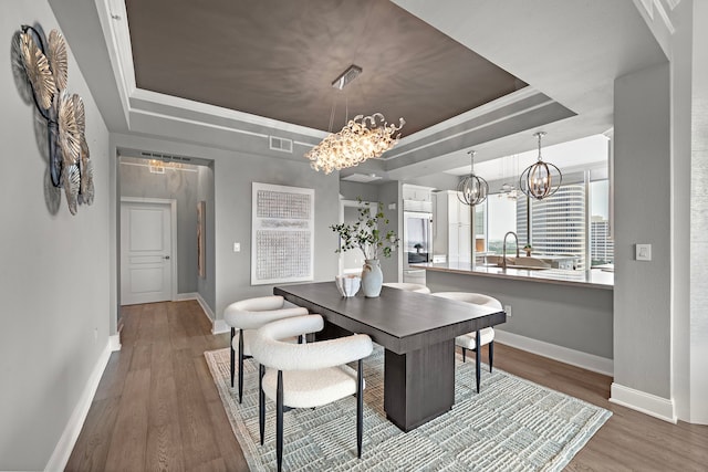 3333 Allen Pkwy Unit 1302, Houston, TX 77019 - dining space featuring a tray ceiling, a chandelier, baseboards, and wood finished floors