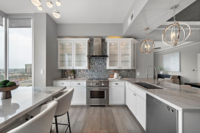 3333 Allen Pkwy Unit 1302, Houston, TX 77019 - kitchen with appliances with stainless steel finishes, wall chimney exhaust hood, a sink, a chandelier, and a peninsula