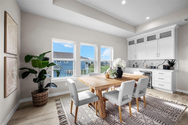 18310 Shaman Dr, Galveston, TX 77554 - dining space featuring wine cooler, bar with sink, light wood-style floors, recessed lighting, and baseboards