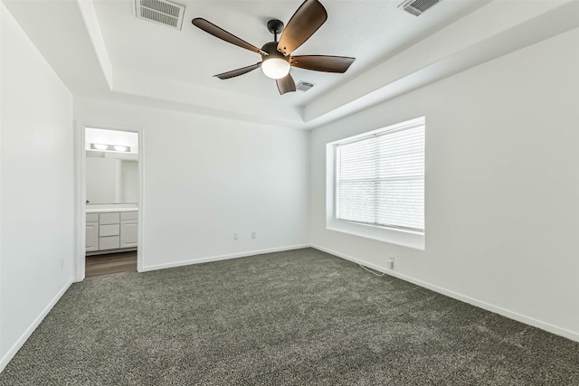 15503 Hickory Dale St, Cypress, TX 77429 - unfurnished bedroom with dark carpet, a tray ceiling, baseboards, ensuite bathroom, and a ceiling fan