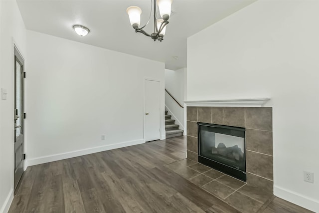 15503 Hickory Dale St, Cypress, TX 77429 - unfurnished living room with a chandelier, dark wood-style floors, baseboards, a tile fireplace, and stairway