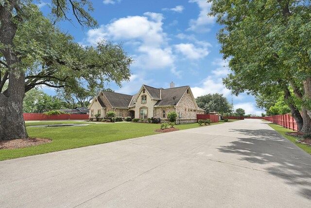 13635 Reeveston Rd, Houston, TX 77039 - french provincial home with a chimney, stone siding, and brick siding
