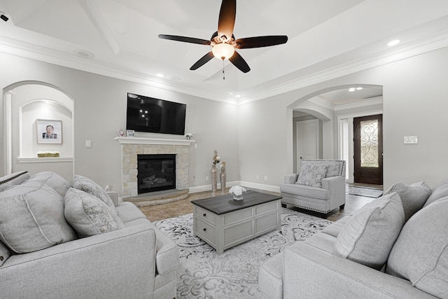 13635 Reeveston Rd, Houston, TX 77039 - living room featuring arched walkways, a ceiling fan, recessed lighting, ornamental molding, and a stone fireplace