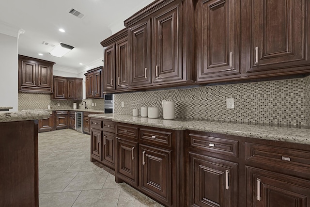 13635 Reeveston Rd, Houston, TX 77039 - kitchen with wine cooler, crown molding, backsplash, dark brown cabinetry, and light stone countertops