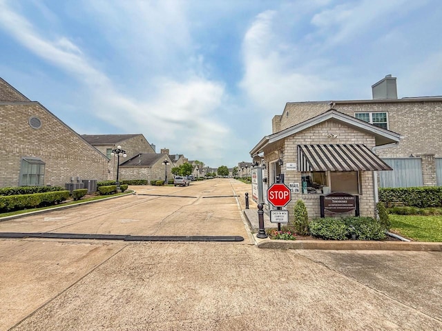 406 Wilcrest Dr Unit 406, Houston, TX 77042 - view of concrete street featuring traffic signs, curbs, a residential view, and street lighting