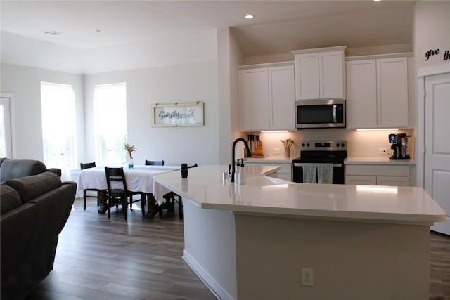 11755 Oakwood Ranch Dr, Willis, TX 77378 - kitchen featuring stainless steel appliances, a sink, dark wood finished floors, light countertops, and white cabinets