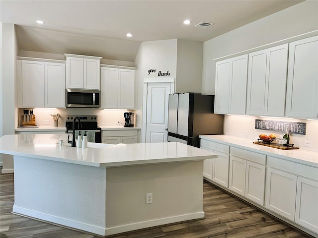 11755 Oakwood Ranch Dr, Willis, TX 77378 - kitchen featuring stainless steel appliances, a sink, white cabinetry, dark wood finished floors, and light countertops