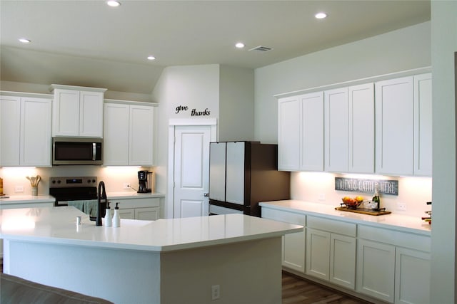 11755 Oakwood Ranch Dr, Willis, TX 77378 - kitchen featuring appliances with stainless steel finishes, a center island with sink, light countertops, white cabinets, and recessed lighting