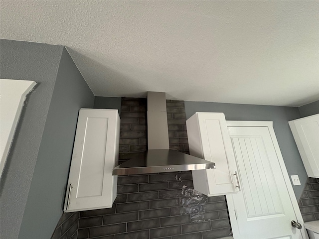 5159 Dumore Dr, Houston, TX 77048 - kitchen view of wall chimney range hood, white cabinetry, and tasteful backsplash