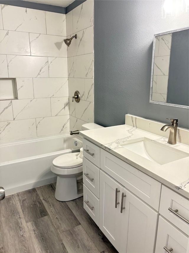 5159 Dumore Dr, Houston, TX 77048 - bathroom with vanity, wood finished floors, toilet, tub / shower combination, and a textured wall