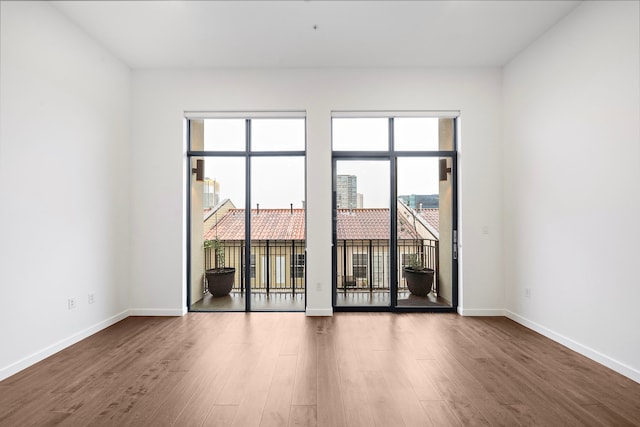 4820 Caroline St Unit 507, Houston, TX 77004 - spare room featuring wood finished floors, healthy amount of natural light, and baseboards
