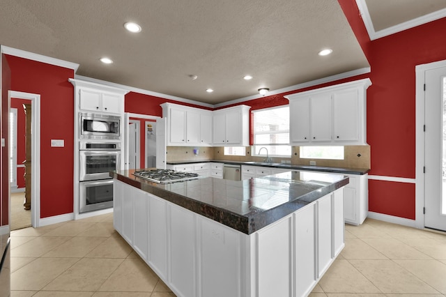 17114 Bur Oak Ct, Spring, TX 77379 - kitchen featuring stainless steel appliances, crown molding, baseboards, white cabinets, and recessed lighting