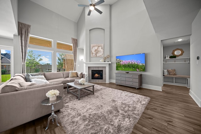 2310 Desert Holly Dr, Katy, TX 77493 - living room with high vaulted ceiling, ceiling fan, baseboards, a tiled fireplace, and wood finished floors