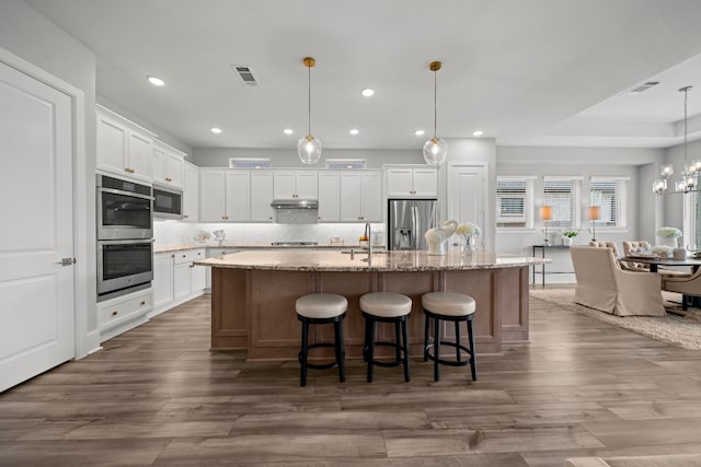 2310 Desert Holly Dr, Katy, TX 77493 - kitchen with stainless steel appliances, recessed lighting, white cabinetry, dark wood-style floors, and decorative backsplash