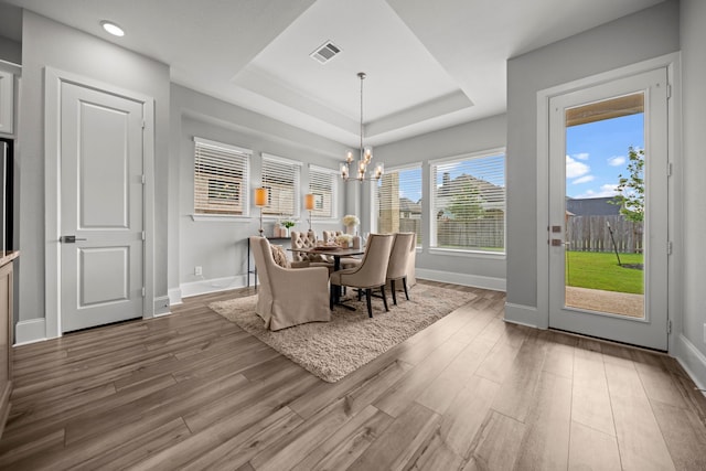 2310 Desert Holly Dr, Katy, TX 77493 - dining area featuring a tray ceiling, wood finished floors, baseboards, a chandelier, and recessed lighting