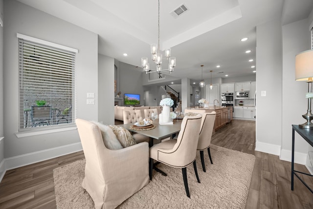 2310 Desert Holly Dr, Katy, TX 77493 - dining room with a chandelier, dark wood-style floors, recessed lighting, baseboards, and a raised ceiling
