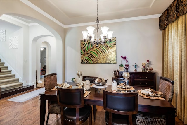 10040 Easton Sky Ln, Cypress, TX 77433 - dining space featuring a chandelier, wood finished floors, arched walkways, stairs, and a tray ceiling