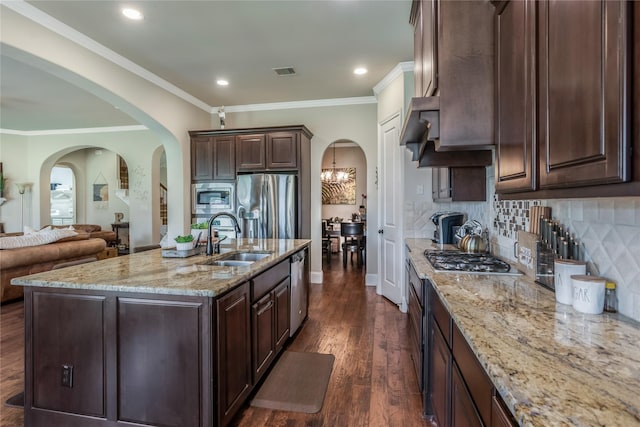 10040 Easton Sky Ln, Cypress, TX 77433 - kitchen featuring appliances with stainless steel finishes, a sink, arched walkways, dark wood-style flooring, and recessed lighting
