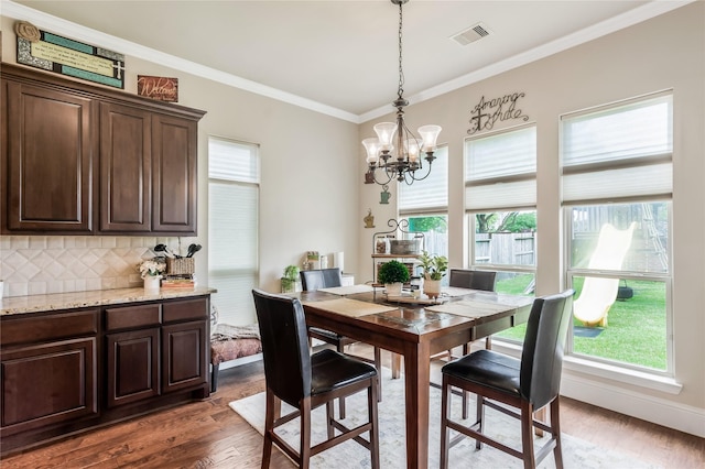10040 Easton Sky Ln, Cypress, TX 77433 - dining space featuring healthy amount of natural light, dark wood finished floors, a chandelier, and ornamental molding