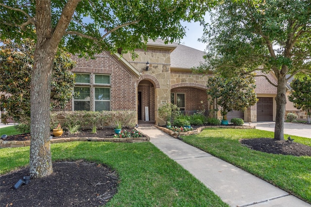 10040 Easton Sky Ln, Cypress, TX 77433 - view of front facade with stone siding, brick siding, a front yard, a garage, and roof with shingles
