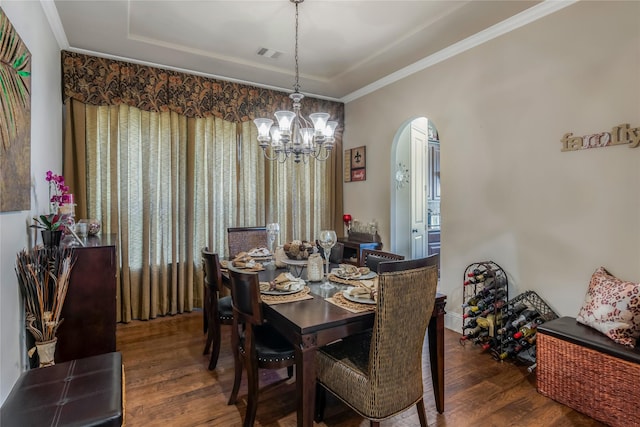 10040 Easton Sky Ln, Cypress, TX 77433 - dining area featuring arched walkways, wood finished floors, a chandelier, a tray ceiling, and crown molding