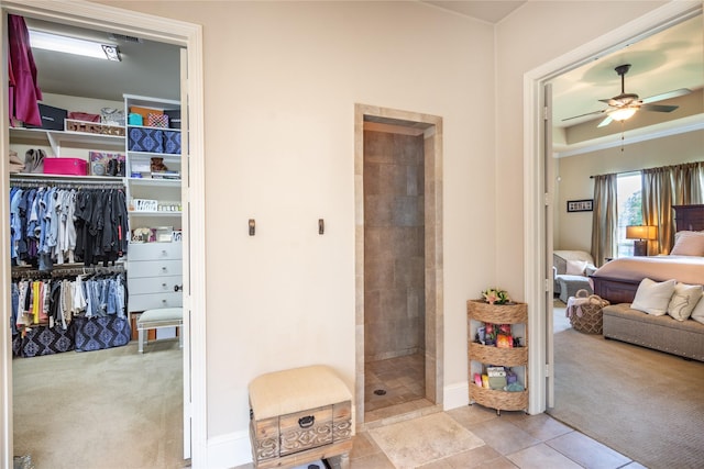 10040 Easton Sky Ln, Cypress, TX 77433 - ensuite bathroom with a ceiling fan, a tile shower, baseboards, tile patterned flooring, and a spacious closet
