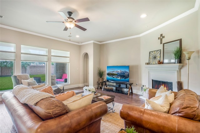 10040 Easton Sky Ln, Cypress, TX 77433 - living area with arched walkways, ornamental molding, a glass covered fireplace, a ceiling fan, and recessed lighting