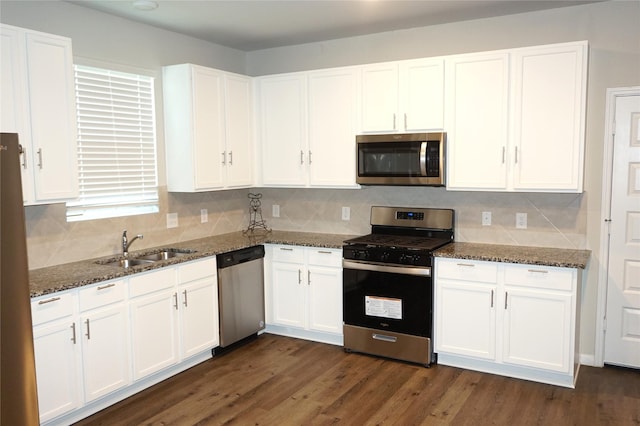 21930 King Heights Ln, Houston, TX 77073 - kitchen with appliances with stainless steel finishes, a sink, white cabinetry, dark stone countertops, and decorative backsplash