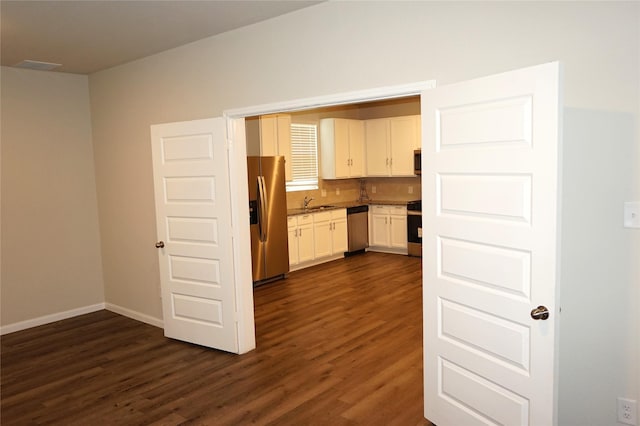 21930 King Heights Ln, Houston, TX 77073 - kitchen featuring appliances with stainless steel finishes, dark wood-style flooring, white cabinetry, and baseboards