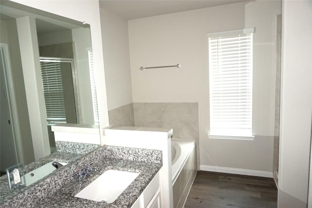21930 King Heights Ln, Houston, TX 77073 - full bathroom with a garden tub, vanity, wood finished floors, a stall shower, and baseboards