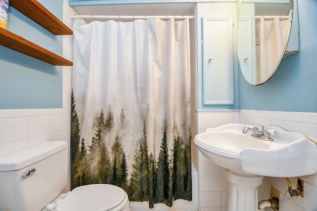 101 Emerald Ct, Houston, TX 77009 - full bath featuring tile walls, toilet, a shower with shower curtain, and wainscoting