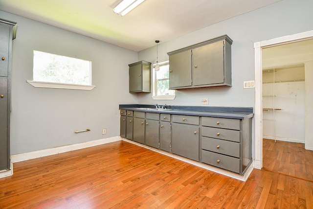 101 Emerald Ct, Houston, TX 77009 - kitchen featuring gray cabinetry, light wood-style floors, dark countertops, and a sink