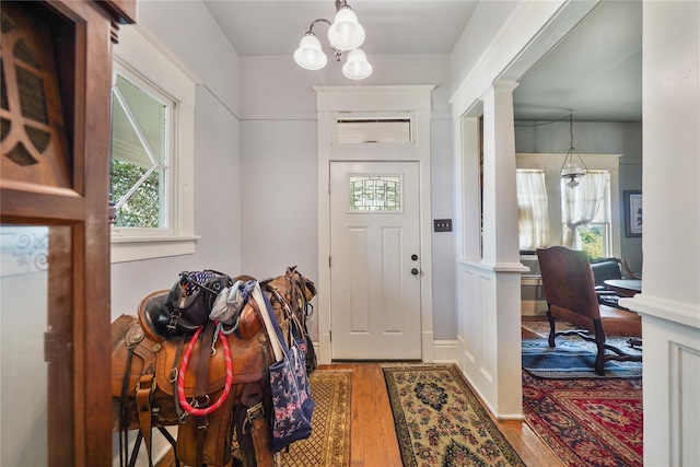 855 County Road 15, Damon, TX 77430 - entryway featuring wood finished floors, decorative columns, and a chandelier