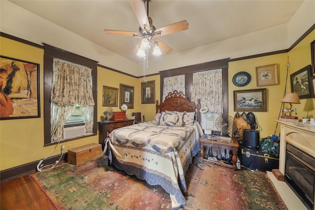 855 County Road 15, Damon, TX 77430 - bedroom with wood finished floors, cooling unit, a fireplace with flush hearth, and a ceiling fan