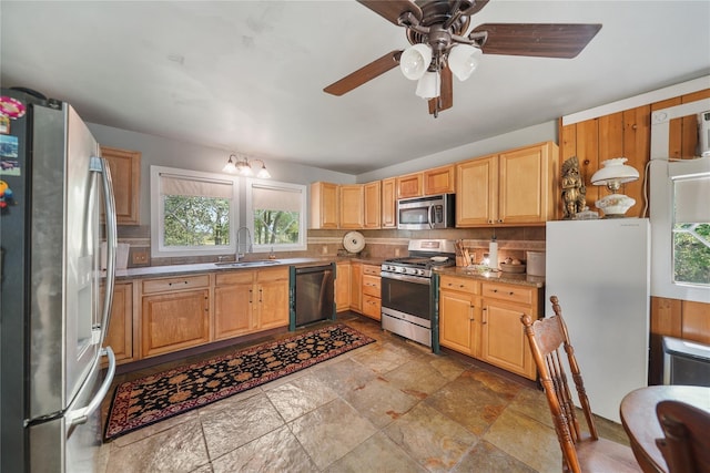 855 County Road 15, Damon, TX 77430 - kitchen featuring appliances with stainless steel finishes, a sink, backsplash, ceiling fan, and light stone finish floors