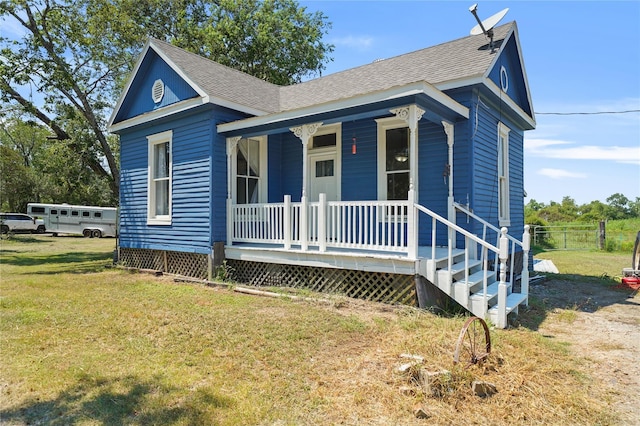 855 County Road 15, Damon, TX 77430 - shotgun-style home with a porch, a front yard, and roof with shingles