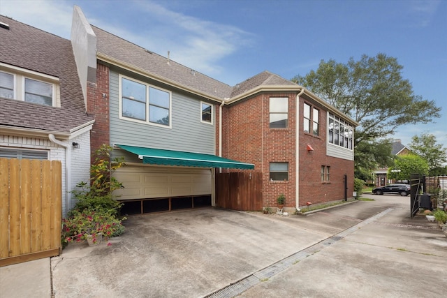 210 Victoria Way, Friendswood, TX 77546 - rear view of property with brick siding, driveway, a garage, and roof with shingles