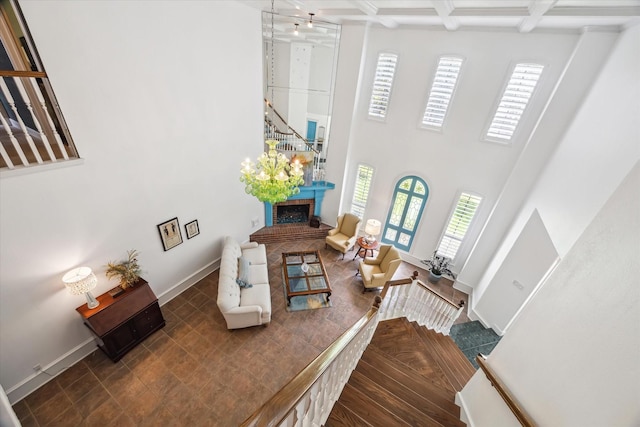 210 Victoria Way, Friendswood, TX 77546 - living room with a towering ceiling, a fireplace, beam ceiling, baseboards, and stairs