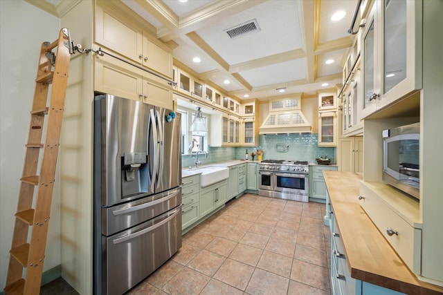 210 Victoria Way, Friendswood, TX 77546 - kitchen with stainless steel appliances, wood counters, premium range hood, a sink, and backsplash