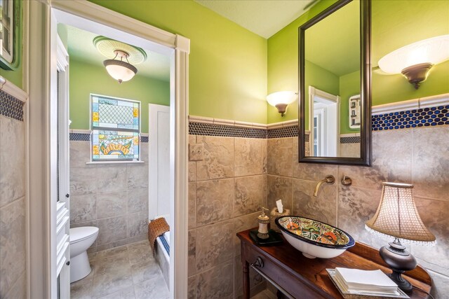 210 Victoria Way, Friendswood, TX 77546 - bathroom with tile walls, toilet, tile patterned floors, and a wainscoted wall