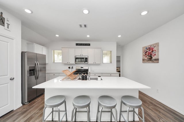 2947 Palominos Way, Conroe, TX 77301 - kitchen featuring stainless steel appliances, dark wood-style floors, a breakfast bar area, healthy amount of natural light, and recessed lighting