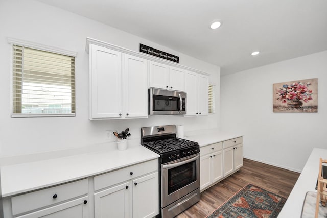 2947 Palominos Way, Conroe, TX 77301 - kitchen featuring appliances with stainless steel finishes, dark wood-style floors, light countertops, white cabinetry, and recessed lighting