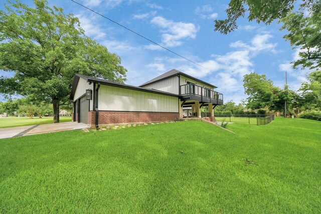 7519 Foster Creek Dr, Richmond, TX 77406 - view of side of home featuring a balcony, brick siding, an attached garage, driveway, and board and batten siding