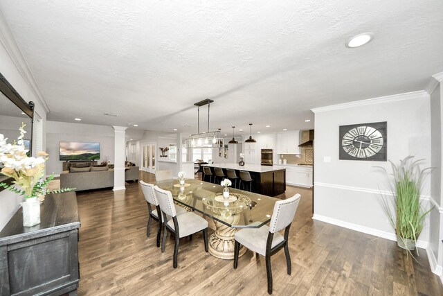 7519 Foster Creek Dr, Richmond, TX 77406 - dining space featuring ornate columns, dark wood-style flooring, ornamental molding, recessed lighting, and a textured ceiling